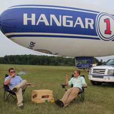 Diego Certuchi and Billy Gallaher relax with cigars between flights on the Hangar One blimp.